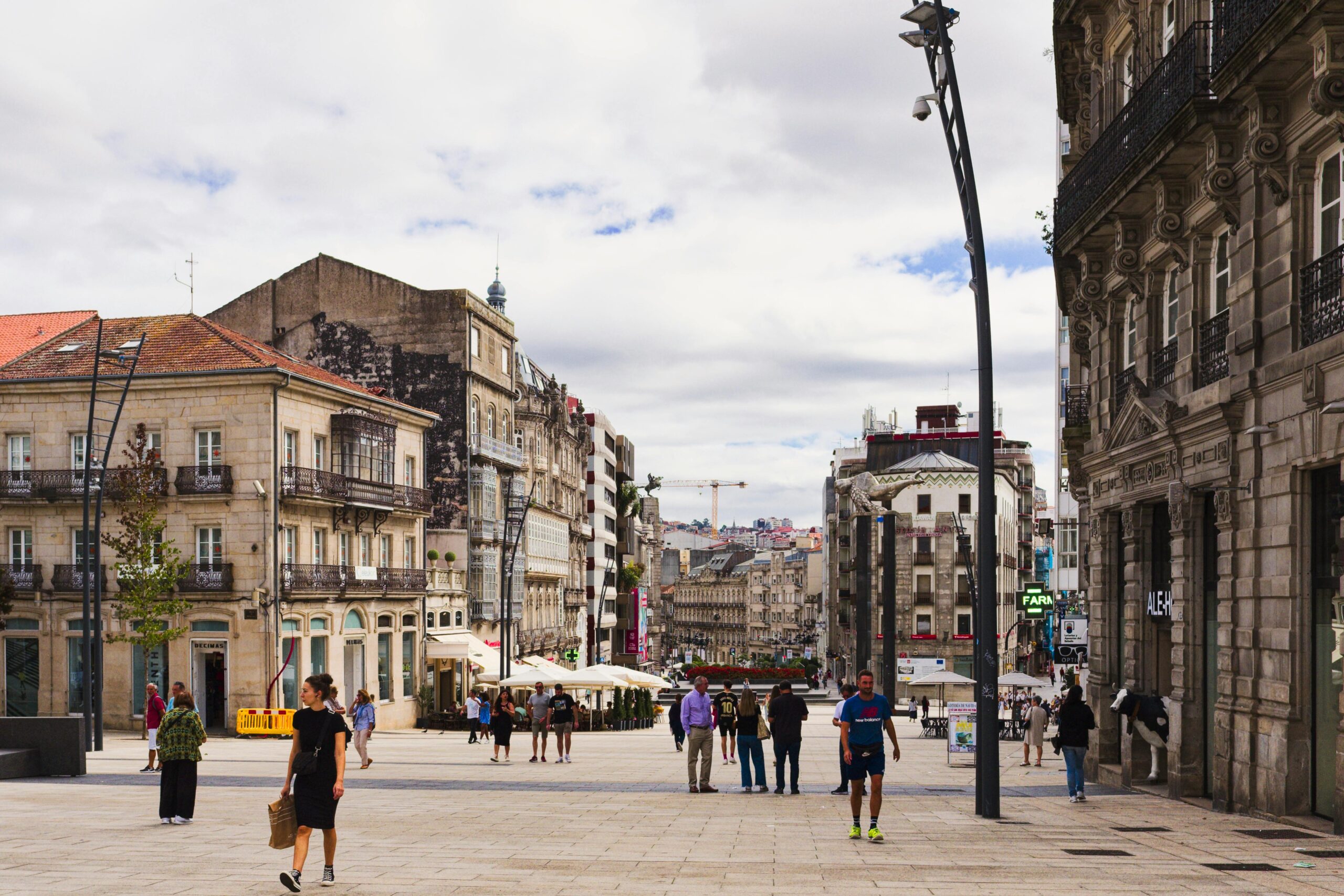 Street view of Vigo, Spain showcasing urban architecture and pedestrians in a lively square.